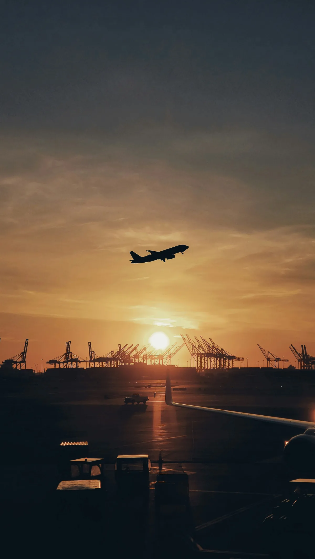 Plane departing at sunset with port cranes — Huntsville air freight and global logistics operations