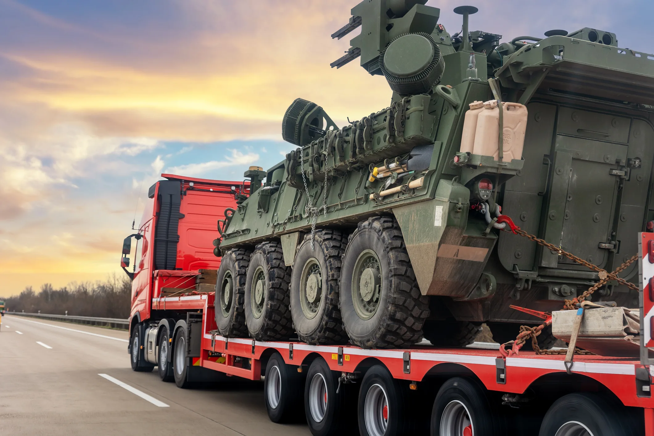 Military armored vehicle on flatbed transport — ITAR-compliant warehousing and defense logistics services in Huntsville, Alabama for defense articles, controlled commodities, and U.S. Munitions List inventory